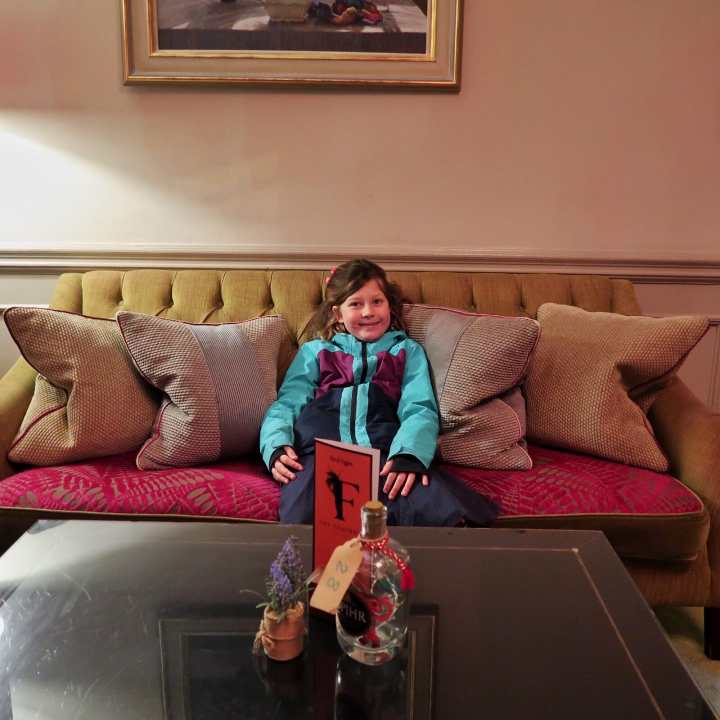 My daughter is relaxing on a sofa in the lounge at The Feathers Hotel Woodstock.