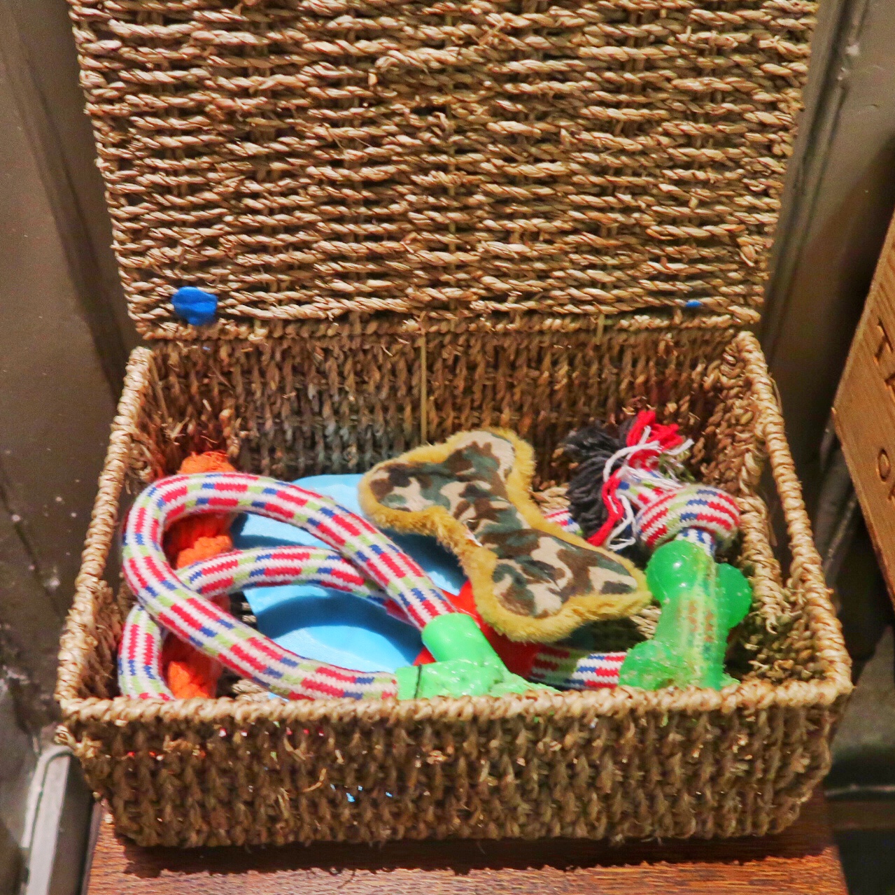 A wicker basket of dog toys to keep your canine friends happy.