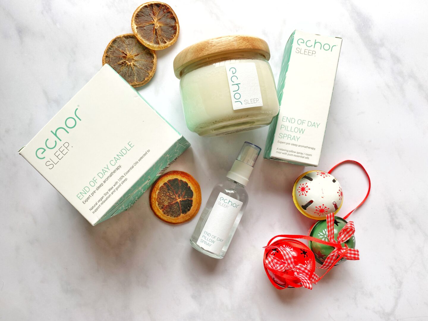 Echor sleep candle and pillow spray in a festive flat lay.
