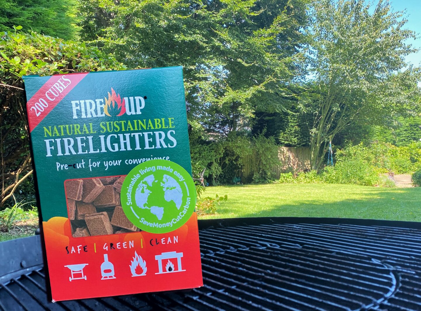 An image of the Fire Up sustainable firelighters on a fire pit in a beautiful green garden.